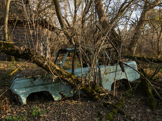 An abandoned village  and car scrap within the Chernobyl exclusion zone. Ukraine