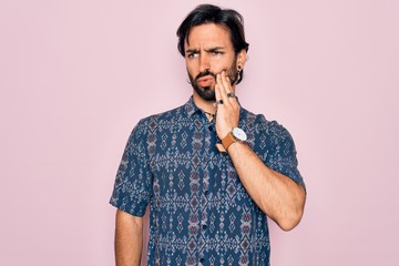 Young handsome hispanic bohemian man wearing hippie style over pink background touching mouth with hand with painful expression because of toothache or dental illness on teeth. Dentist