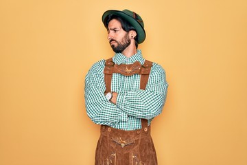 Young handsome man wearing tratidional german octoberfest custome for Germany festival looking to...