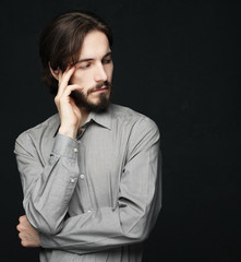 unhappy man touching his forehead over black background