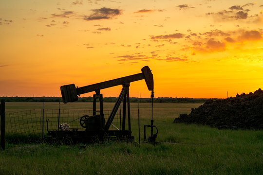 A Silhouette of a Texas oil drill at sunset