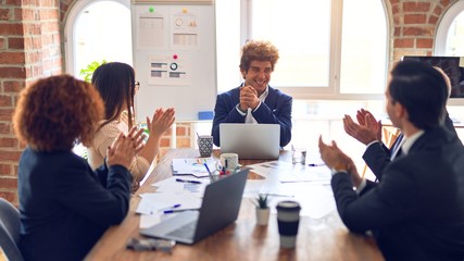Group of business workers smiling happy and confident in a meeting. Working together looking at presentation using board and laptop applauding at the office.