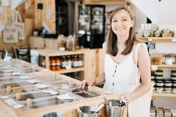 Woman buying dry goods in sustainable plastic free grocery store