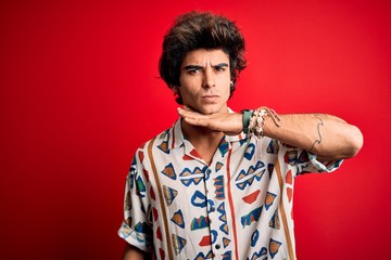 Young handsome man on vacation wearing summer shirt over isolated red background cutting throat with hand as knife, threaten aggression with furious violence