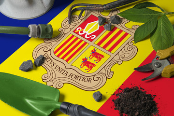 Andorra flag with gardening tools background on table. Spring in the garden concept with free copy space.