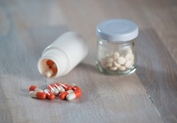 Bottle of colorfull medicine capsule on wooden background.