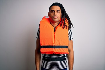 Young african american afro man with dreadlocks wearing orange lifejacket with serious expression...