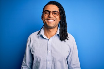 Young handsome african american man with dreadlocks wearing casual shirt and glasses with a happy and cool smile on face. Lucky person.