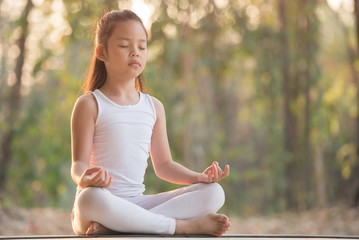 calmness and relax, female happiness.Horizontal, blurred background. little asian girl meditates...