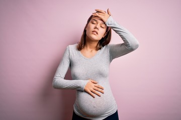 Young beautiful teenager girl pregnant expecting baby over isolated pink background Touching forehead for illness and fever, flu and cold, virus sick