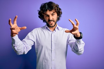 Young handsome business man with beard wearing shirt standing over purple background Shouting frustrated with rage, hands trying to strangle, yelling mad