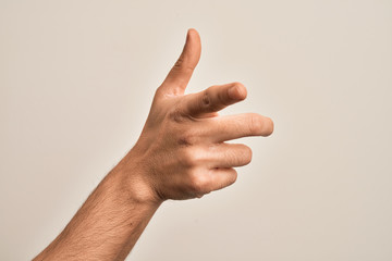 Hand of caucasian young man showing fingers over isolated white background pointing forefinger to the camera, choosing and indicating towards direction