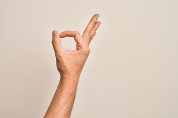 Hand of caucasian young man showing fingers over isolated white background gesturing approval...