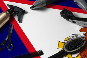 American Samoa flag with hair cutting tools. Combs, scissors and hairdressing tools in a beauty...