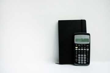 Business calculator with a black notebook on a white background