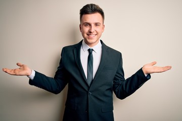 Young handsome business man wearing elegant suit and tie over isolated background smiling showing both hands open palms, presenting and advertising comparison and balance