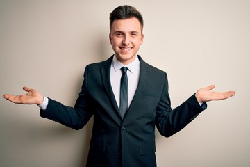 Young handsome business man wearing elegant suit and tie over isolated background smiling showing...