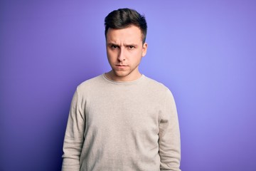 Young handsome caucasian man wearing casual sweater over purple isolated background skeptic and nervous, frowning upset because of problem. Negative person.