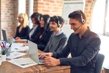 Group of call center workers smiling happy and confident. Working together with smile on face using headset at the office.
