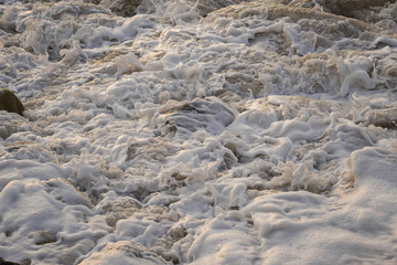 Espuma del mar de mazatlan chocando con las rocas y la arena