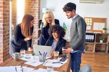 Group of business workers smiling happy and confident. Working together with smile on face  using laptop at the office