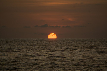 Fototapeta na wymiar Atardecer - sol rojo cruzando el mar de mazatlan