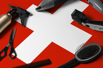 Switzerland flag with hair cutting tools. Combs, scissors and hairdressing tools in a beauty salon desktop on a national wooden background.