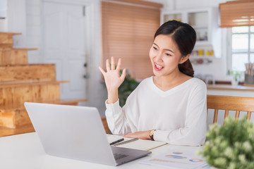 Young Asian businesswoman work at home and virtual video conference meeting with colleagues business people, online working, video call due to social distancing