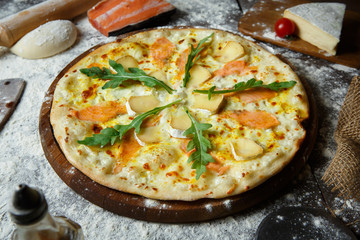 Italian salmon pizza with brie cheese and arugula
