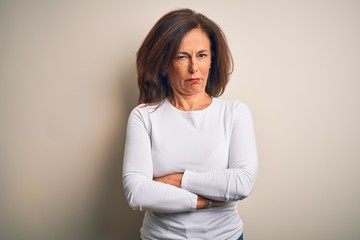 Fototapeta premium Middle age beautiful woman wearing casual t-shirt standing over isolated white background skeptic and nervous, disapproving expression on face with crossed arms. Negative person.