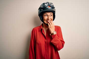 Middle age motorcyclist woman wearing motorcycle helmet over isolated white background looking stressed and nervous with hands on mouth biting nails. Anxiety problem.