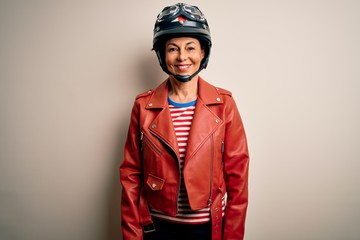 Middle age motorcyclist woman wearing motorcycle helmet and jacket over white background with a happy and cool smile on face. Lucky person.