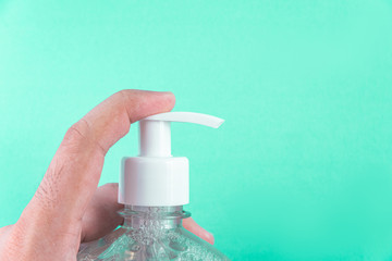 Man hand in container with alcohol gel on the light blue background
