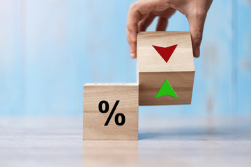 business man Hand change wood cube block with percentage to UP and Down arrow symbol icon. Interest...