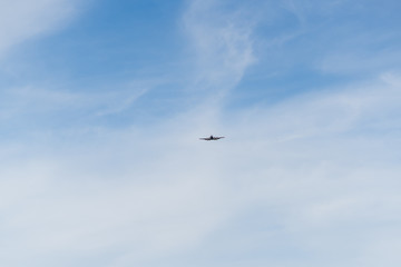 Fototapeta na wymiar Airplane on a cloudy sky background on a sunny day.