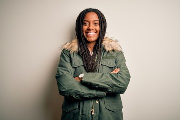 Young african american woman wearing winter parka coat over isolated background happy face smiling with crossed arms looking at the camera. Positive person.