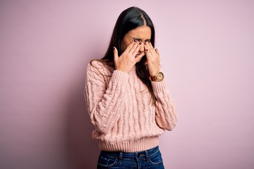 Young beautiful brunette woman wearing casual sweater over isolated pink background rubbing eyes...
