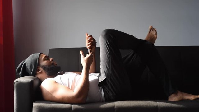 Black man at home using his phone and card to order food online during quarantine time