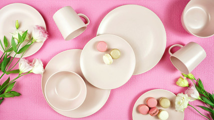 Obraz na płótnie Canvas Top view of modern pastel pink, ceramic tableware on pink nackground. Creative concept cooking, kitchen flatlay layout.