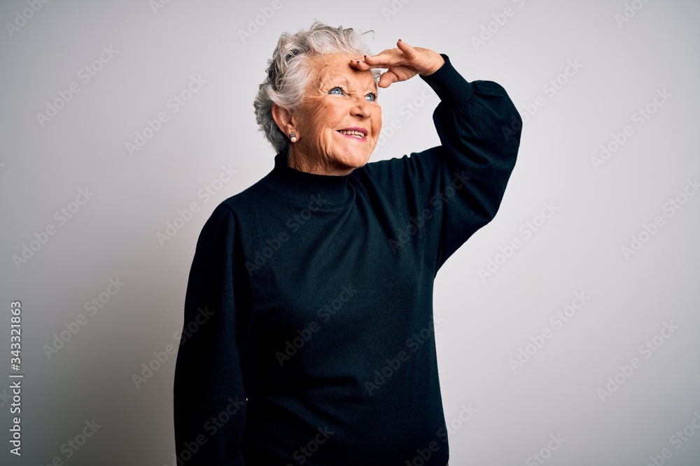 Wall mural senior beautiful woman wearing casual black sweater standing over isolated white background very hap