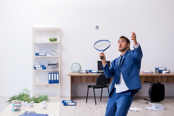 Young male employee playing tennis in the office
