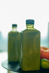Two bottles of healthy green smoothie mixed with fruits and vegetables