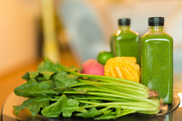 Two bottles of healthy green smoothie mixed with fruits and vegetables
