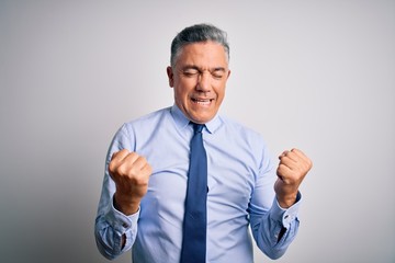 Middle age handsome grey-haired business man wearing elegant shirt and tie celebrating surprised and amazed for success with arms raised and eyes closed. Winner concept.
