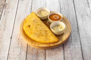 empanada with assorted sauces