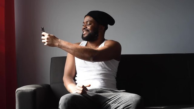 Black man at home using his phone and card to order food online during quarantine time