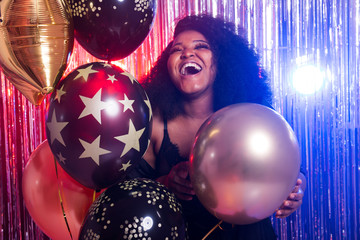 Portrait of a beautiful african american woman against twinkling background. Birthday party,...