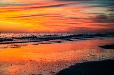 Naklejka na ściany i meble sunset on the beach, sea, sky, orange, turquoise, ocean, reflection, waves, clouds, shore, sand, evening