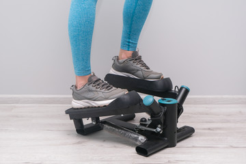 Woman exercising on a twister  stepper. Digital display, keeping fit at home.  Home cardio workout.