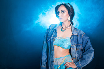 Obraz premium Magic, cosplay and fairy tale concept - Portrait of a young woman in the image of an Eastern fairy Princess on blue background.